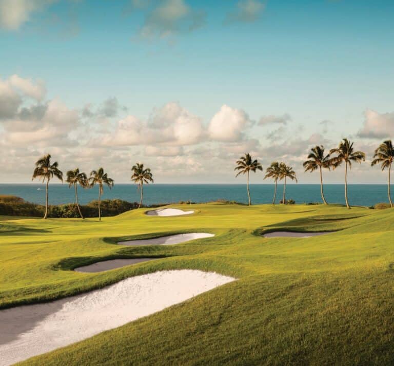 A scenic view of the golf course at the Royal Sonesta Kauai Resort, showcasing lush greenery and tropical surroundings.