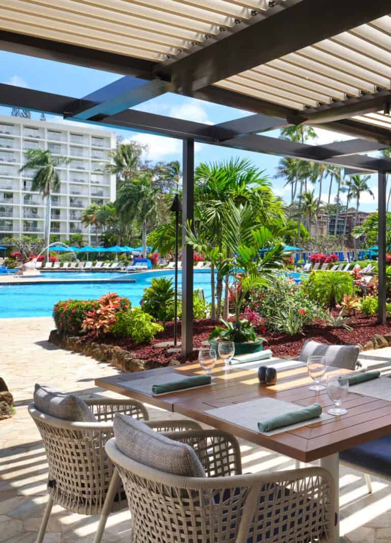 Patio at the Royal Sonesta Kauai Resort, featuring beach views and dining areas, set in Puerto Rico's tropical landscape.