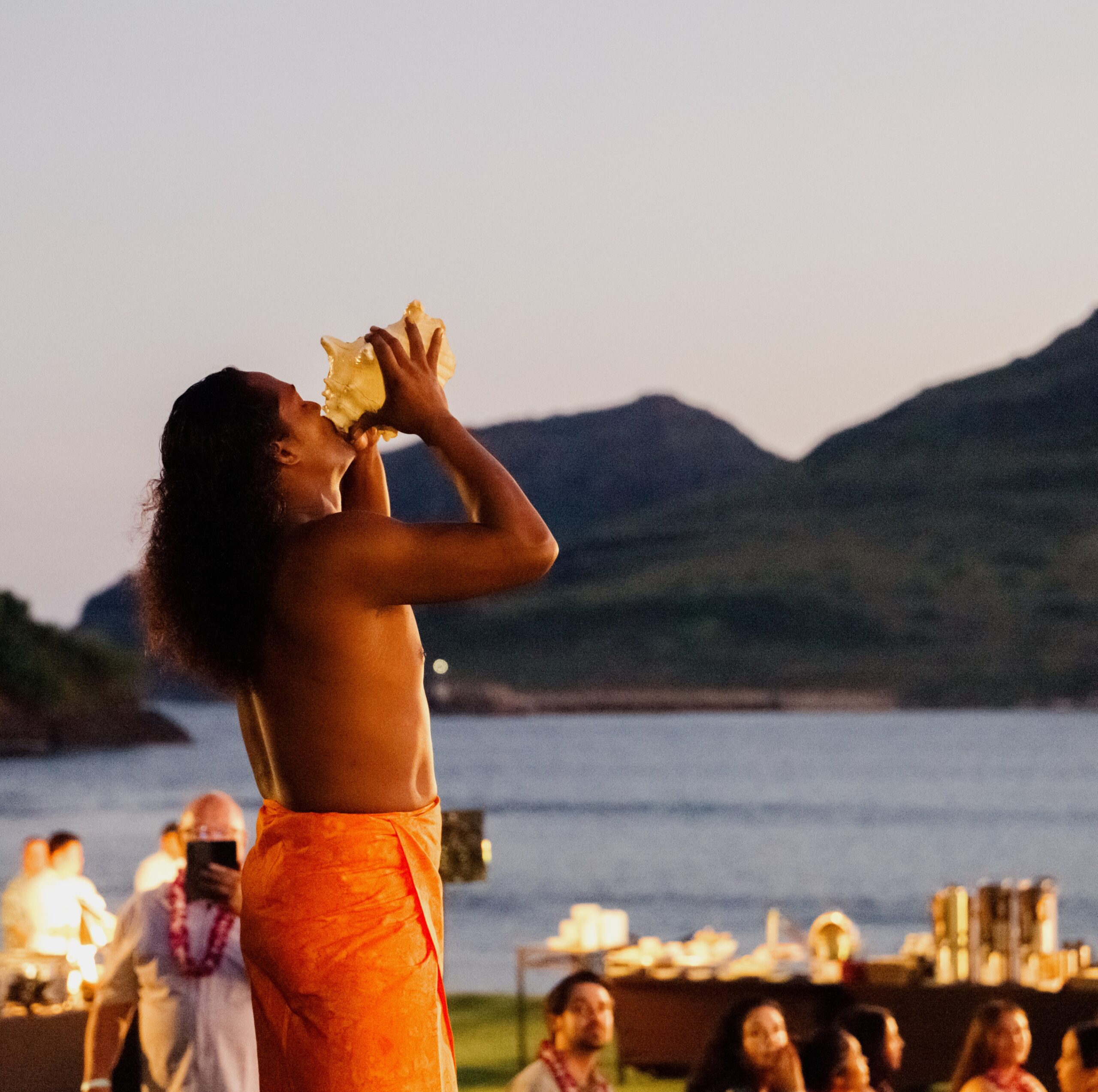 In Hawaii, a man wearing an orange robe performing at the event.